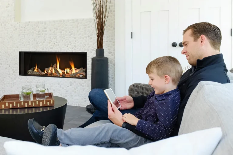Get an Estimate Father and Son looking at a phone while sitting by a fireplace
